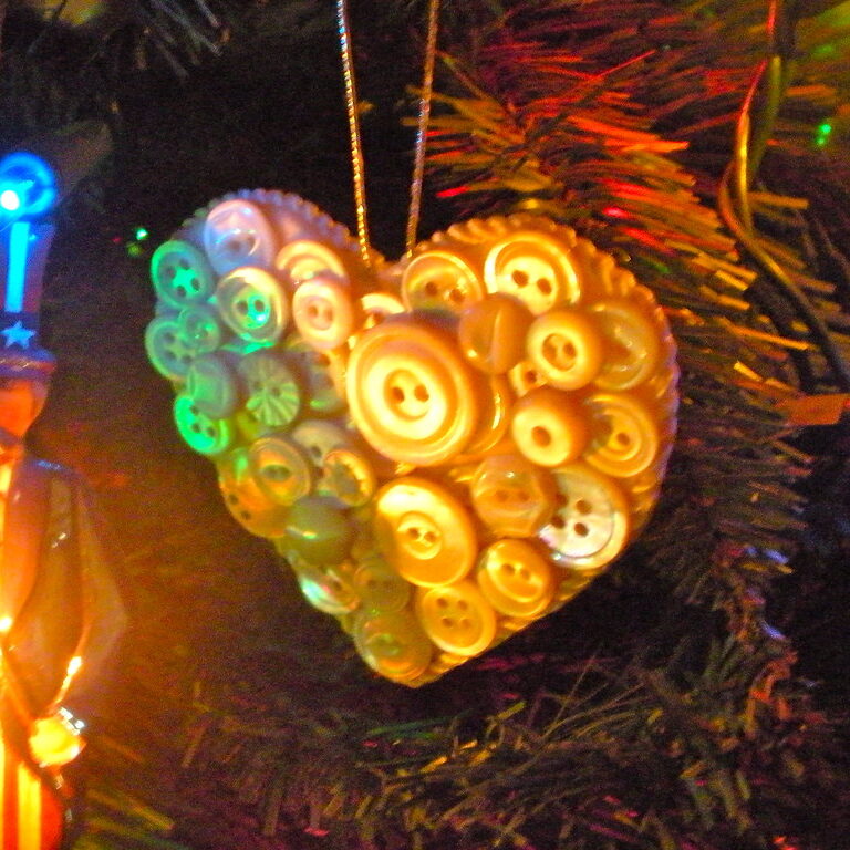 close up of a hand made button ornament on a holiday tree