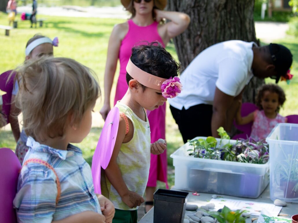 2 young kids making fairy gardens outside at Fairy Fest