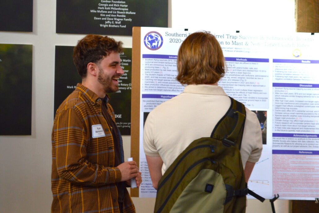 a college student presenting their research poster