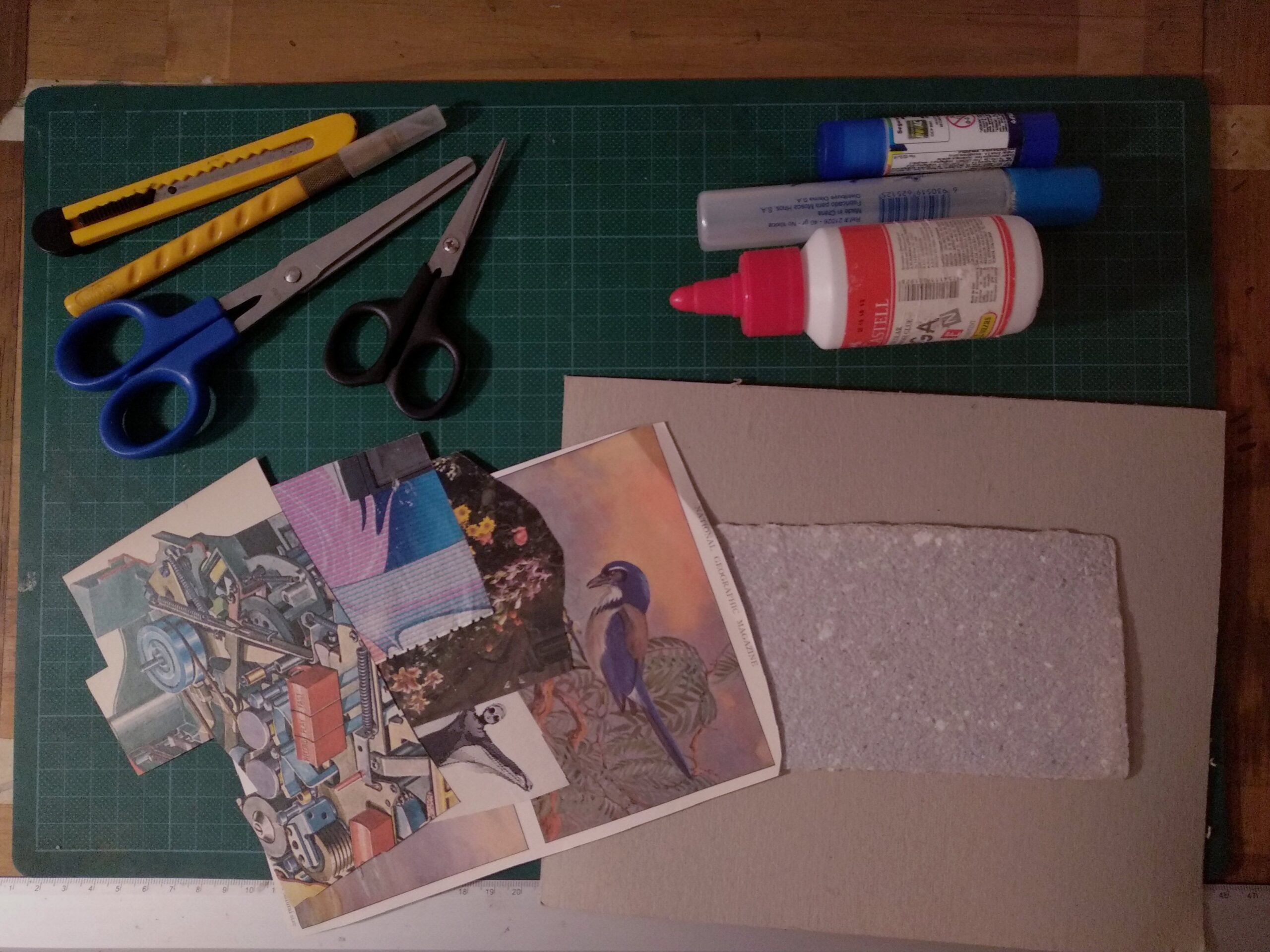 collage making supplies on a table including scissors, photo clippings, paper, and glue