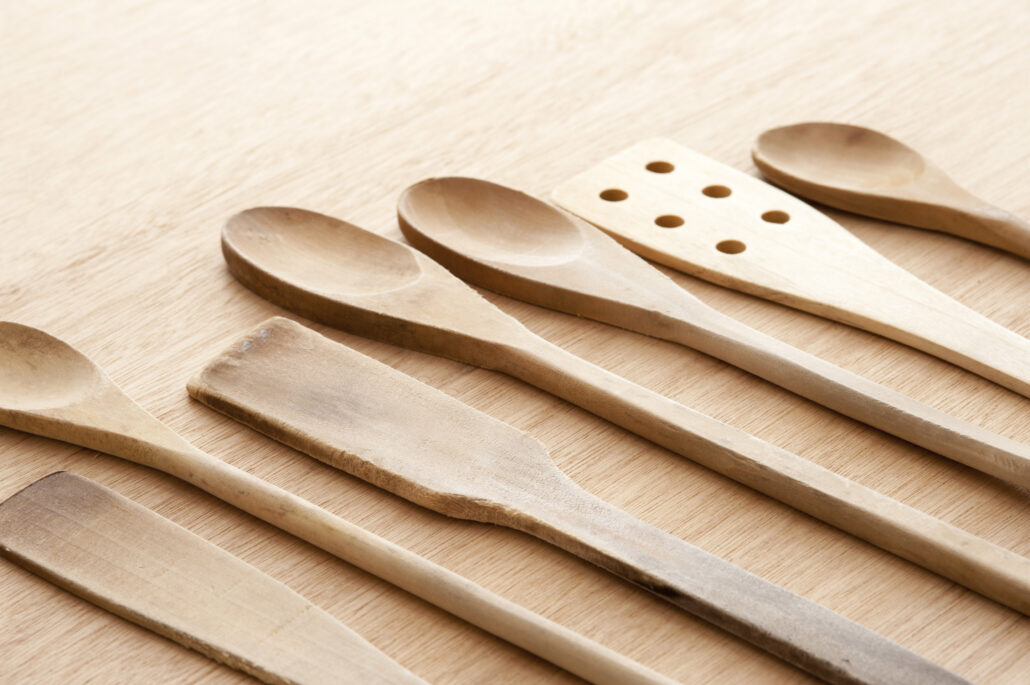 an array of wooden kitchen utensils on a table